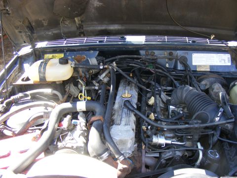 Engine bay with hoses and wiring visible. Supermotors.net logo in corner