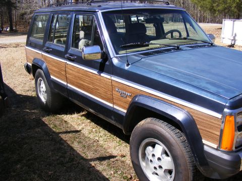 Blue Jeep Cherokee with wood paneling, 3/4 front view