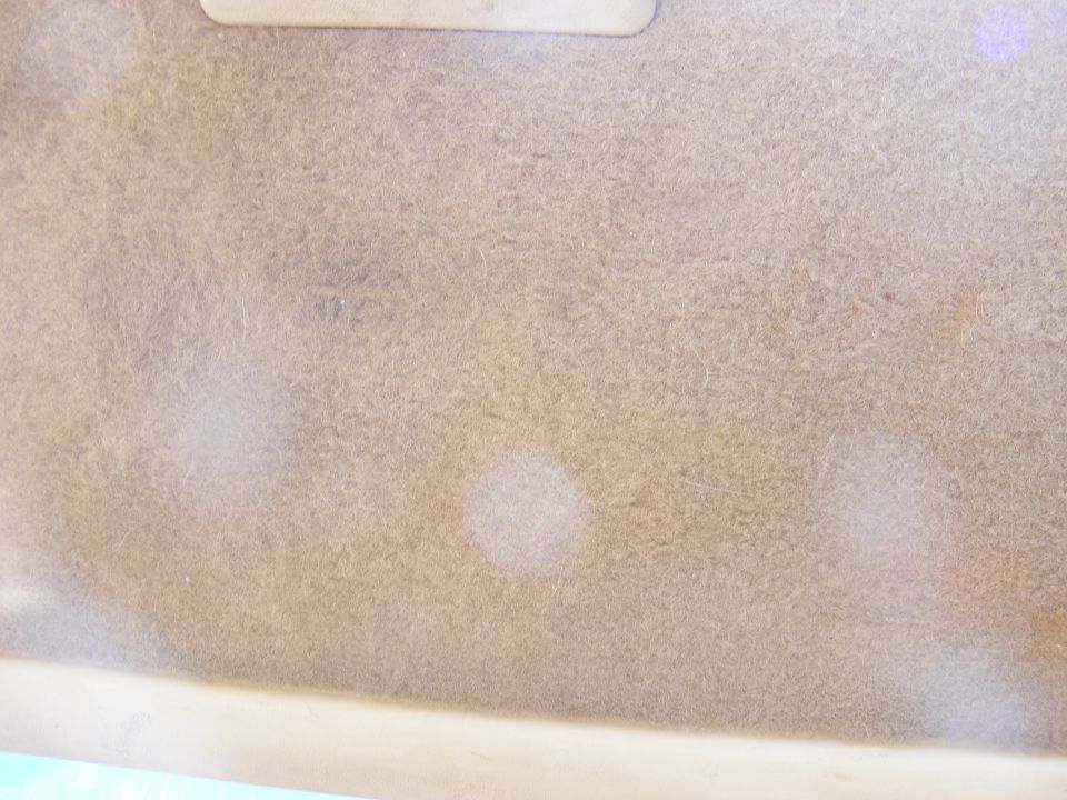 Tan headliner with light stains and a light-colored trim piece at the top