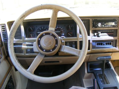Tan Jeep Cherokee interior with a worn steering wheel and dashboard