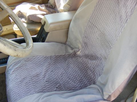 Interior view of a vehicle showing patterned seat covers and dashboard