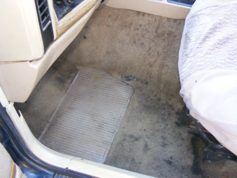 Vehicle interior floor with rubber mat and part of a seat visible