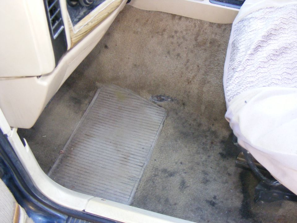 Vehicle interior floor with rubber mat and part of a seat visible