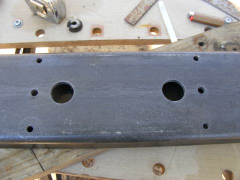 Metal frame with two large circular holes and smaller bolt holes