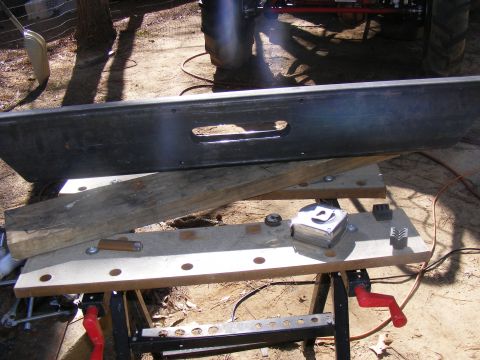Black tailgate with a rectangular cutout, resting on a workbench with tools