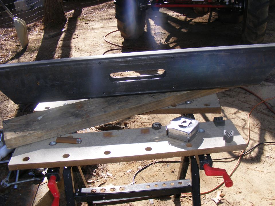 Black tailgate with a rectangular cutout, resting on a workbench with tools