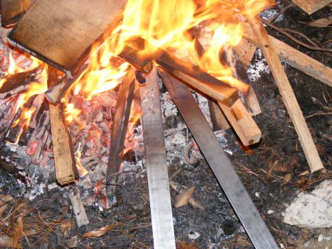 Wood and metal pieces burning in a campfire