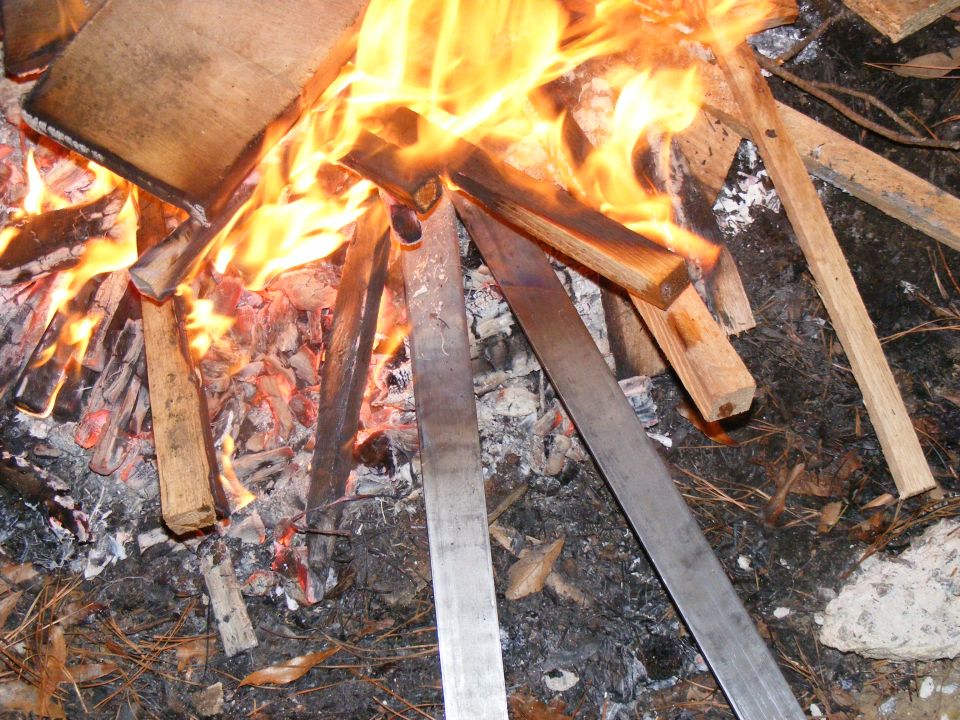 Wood and metal pieces burning in a campfire
