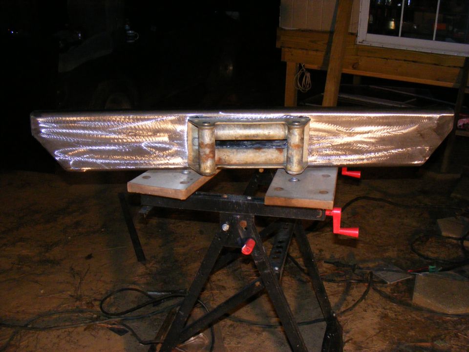Custom steel bumper with a rusty winch mounted on a black sawhorse