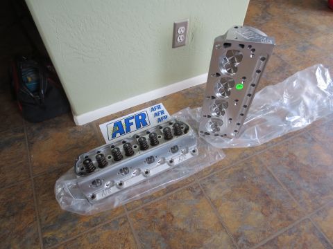 1996 Ford Bronco - Two AFR aluminum engine cylinder heads are displayed on a tiled floor.