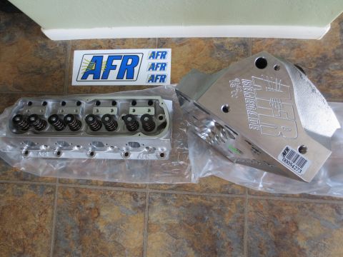 1996 Ford Bronco - Two AFR Renegade aluminum cylinder heads are displayed, one with visible valve springs and the other with embossed branding.