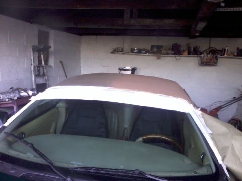 1998 Ford Crown Victoria - Interior view of a car with its convertible top undergoing work, covered in protective materials.