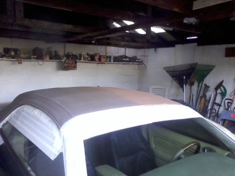 1998 Ford Crown Victoria - A car's interior is visible as its convertible top is taped off, likely for protection or repair.