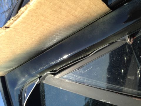 1990 Ford Bronco - Wood paneling is attached to the car's door frame, obscuring the view of the vehicle.