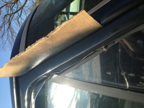 1990 Ford Bronco - A piece of cardboard is used to protect the window trim of a vehicle.