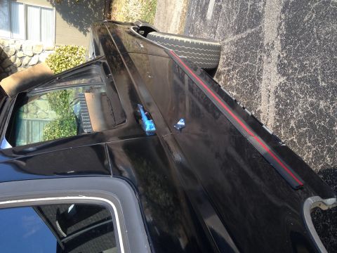 1990 Ford Bronco - This black SUV has a distinctive body style and a red stripe accent on its side.