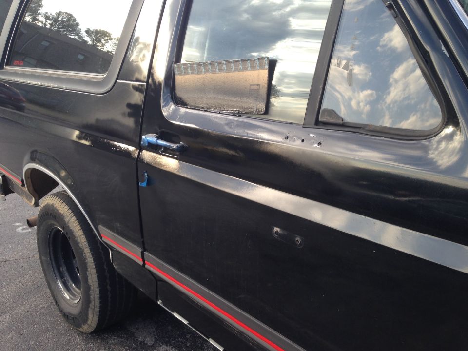 Black SUV side door with chrome trim and red stripe