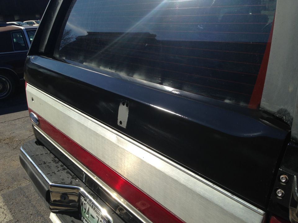 Rear of a black and white Ford Bronco with a red stripe. License plate visible
