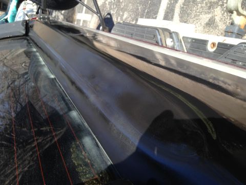 1990 Ford Bronco - Rear window trim detail on a vehicle, with other vehicles visible in the background.