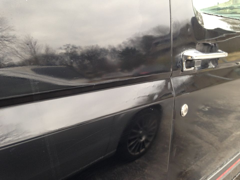 side of a black SUV, showing door handle and wheel