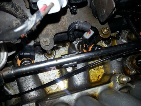 1989 Ford F-150 - This image shows a close-up view of fuel injectors and associated engine components, likely part of a vehicle's fuel delivery system.