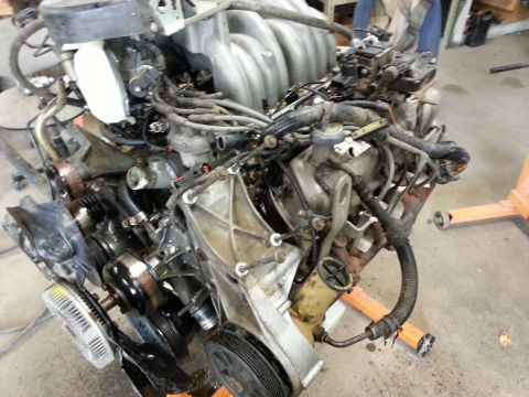 1989 Ford F-150 - This engine assembly is mounted on an orange engine stand, likely for repair or replacement.
