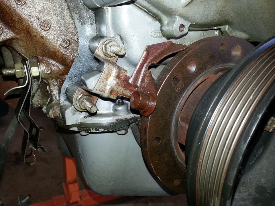 Close-up of engine pulley and bracketry, showing rust and wear