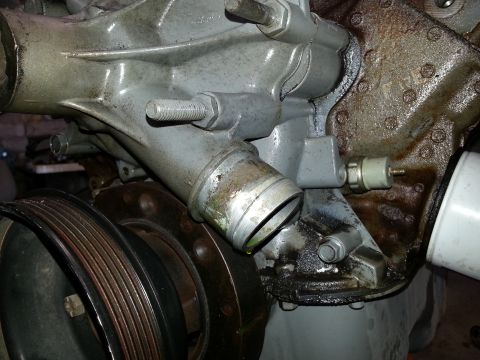 1989 Ford F-150 - This image shows a close-up view of an engine's water pump and pulley system, with visible signs of wear and potential leaks.