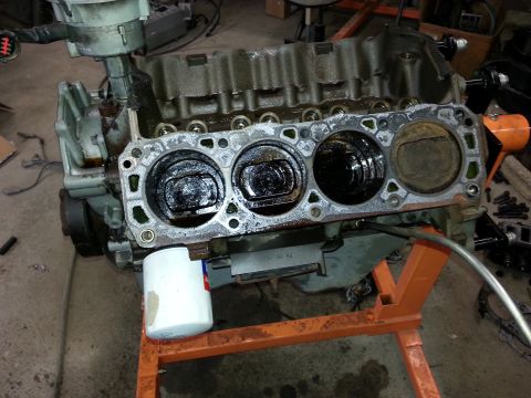 1989 Ford F-150 - A disassembled engine block rests on an orange engine stand, showing the cylinders and pistons.