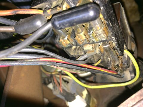 1964 Ford Ranchero - A close-up view of a vehicle's complex electrical wiring harness and fuse box, showing multiple wires and fuses.