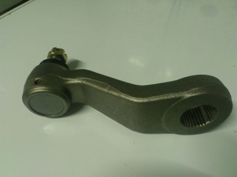 1998 Ford Crown Victoria - A close-up view of a metal steering pitman arm, a component of a vehicle's steering system.