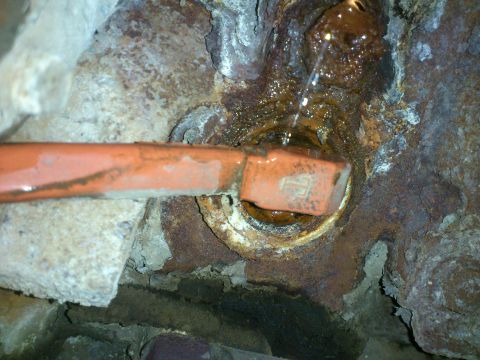 1998 Ford Crown Victoria - Close-up of a corroded cylinder block heater with visible water leakage.
