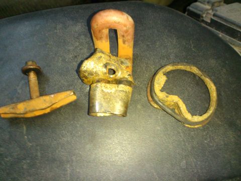 1998 Ford Crown Victoria - Three rusty parts believed to be from a cylinder block heater are laid out on a dark surface.
