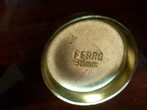 1998 Ford Crown Victoria - A close-up view of a brass cylinder block heater cap shows stamped text indicating 'FERRO 38mm'.