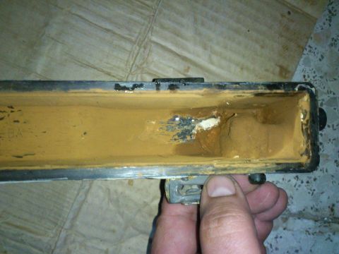 1998 Ford Crown Victoria - A hand holds a corroded radiator tank, showing internal rust and deposits, indicating a potential leak issue.