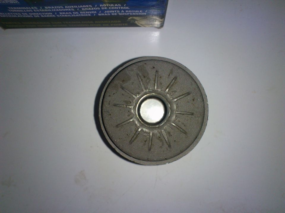 Upper control arm bushing with radial lines on a white surface