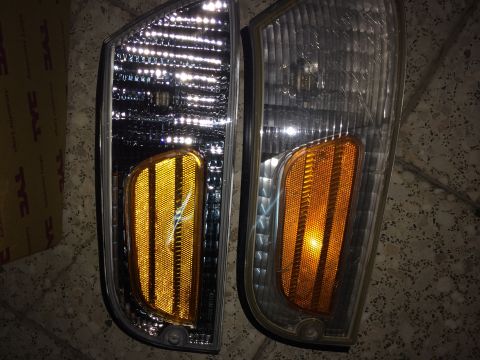1998 Ford Crown Victoria - A pair of vehicle headlights are shown, one with a box and the other with a website watermark.