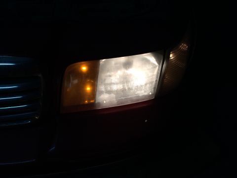 1998 Ford Crown Victoria - Close-up of the front headlight assembly of a 1998 Ford Crown Victoria, showing the turn signal and main headlight.