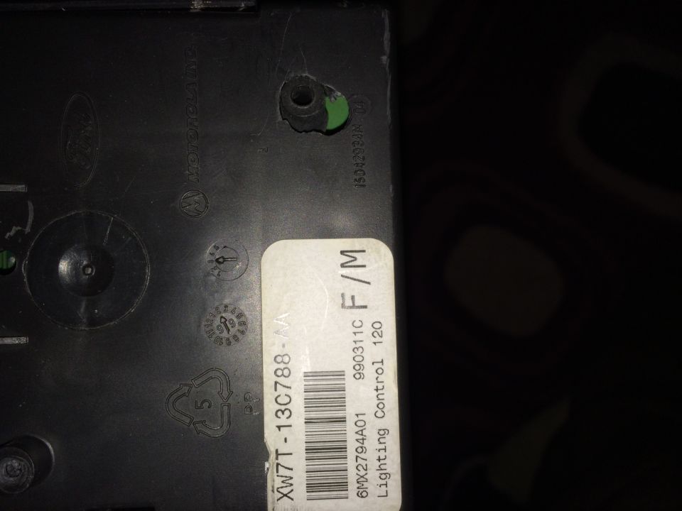 Close-up of a black plastic part with a white label that says "Lighting Control 120"