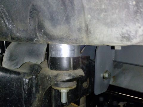 1995 Ford Bronco - Close-up of a suspension lift spacer attached to a vehicle frame.