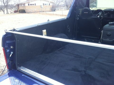1982 Ford Bronco - The interior of a blue pickup truck is visible, including the seats and steering wheel.