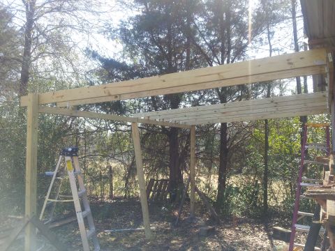 1986 Ford Bronco - Construction of a wooden frame structure outdoors with trees in the background.