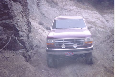 1992 Ford Bronco - 1992 Ford Bronco navigating a rough dirt road in a canyon.