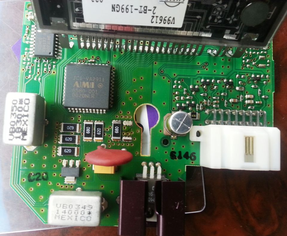Green instrument cluster PCB with AMI JCI-VA2911 chip, oscillators, and white connector