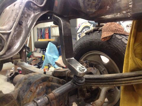 1993 Ford Bronco - Detail shot of the frame and suspension system, with a tire in the background. The registry information may be inaccurate.