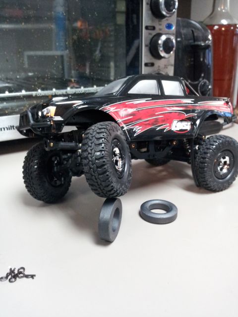 1995 Ford Bronco - This remote control monster truck features a black body with red flame graphics and oversized off-road tires.