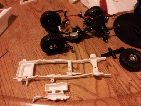 1995 Ford Bronco - RC car chassis and parts are assembled on a wooden table.
