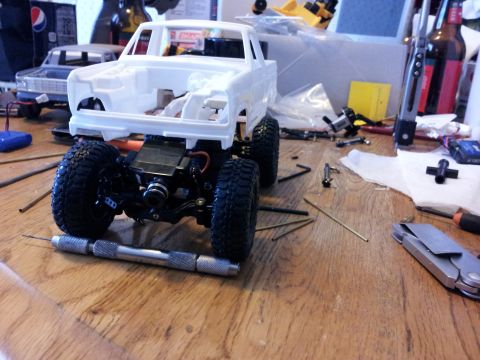 1995 Ford Bronco - Model truck chassis assembly in progress, with tools and parts scattered around.