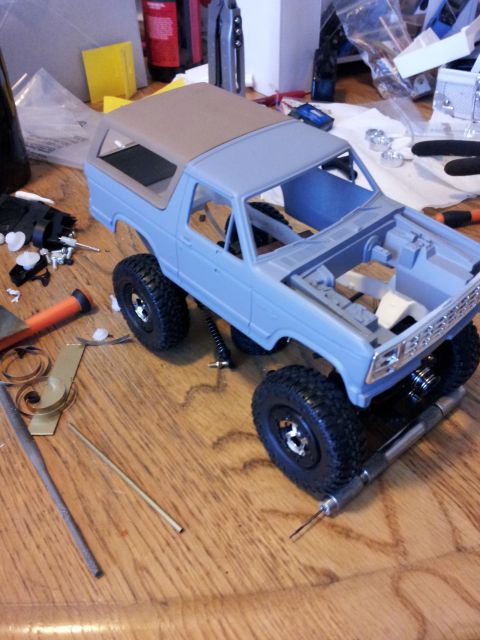 1995 Ford Bronco - Unfinished model of a 1995 Ford Bronco sits on a workbench surrounded by tools and parts.