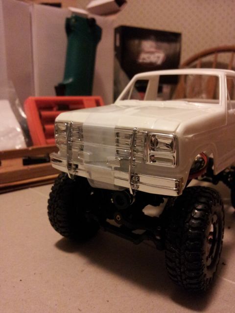 1995 Ford Bronco - Front view of a white model truck with a chrome grille and off-road tires.